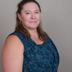 Woman in teal patterned sleeveless blouse