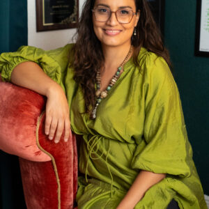 Smiling woman wearing glasses and green dress