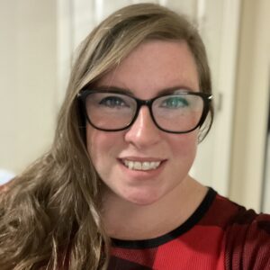 Smiling woman with glasses wearing red plaid
