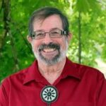 Smiling man in red shirt with bolo tie